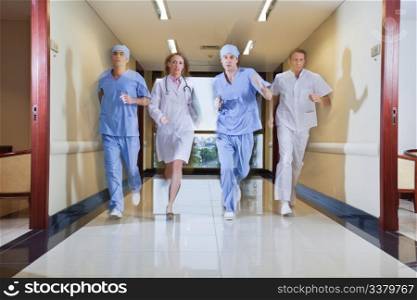 Team of surgeon and nurse running in hallway of hospital