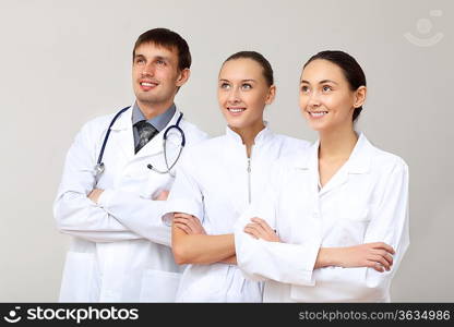 Team of three young doctors in white uniform