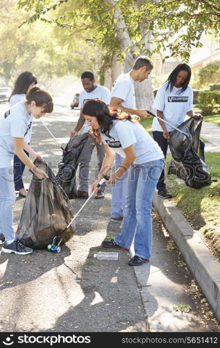 Team Of Volunteers Picking Up Litter In Suburban Street