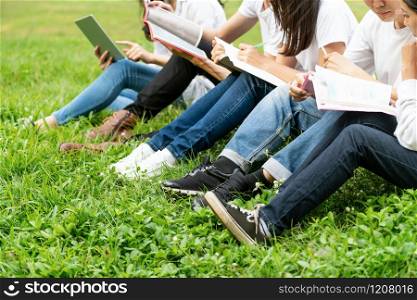 Team of young students studying in a group project in the park of university or school. Happy learning, community teamwork and youth friendship concept.