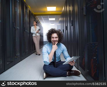 Team of young technicians working together on servers at the data center using tablet computers