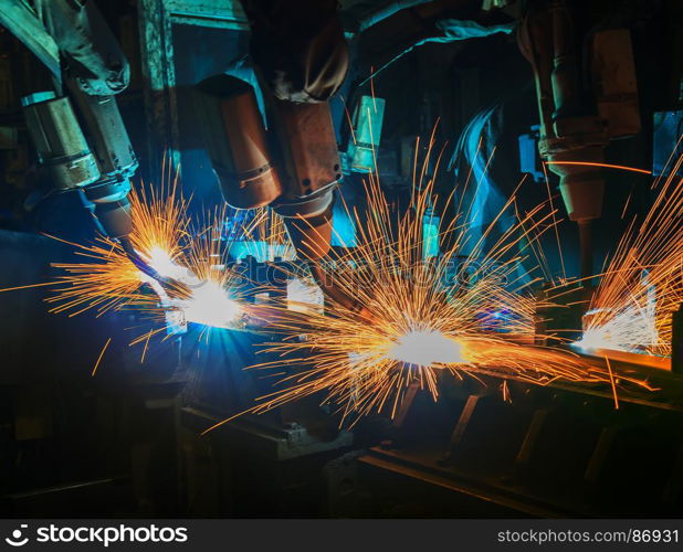 Team robots are welding assembly part in car factory