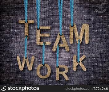 Team work Letters hanging strings with blue sackcloth background.. Team work