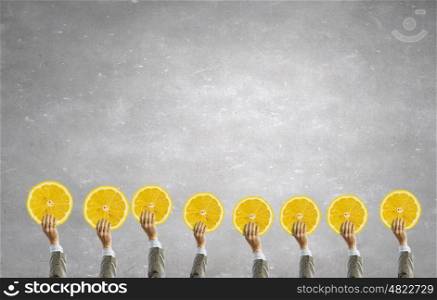 Teamwork and creativity concept. Group of business people holding lemon slice in raised hands