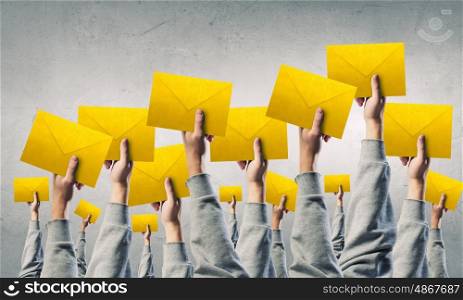 Teamwork and Email concept. Crowd of businesspeople lifting up hands with email signs