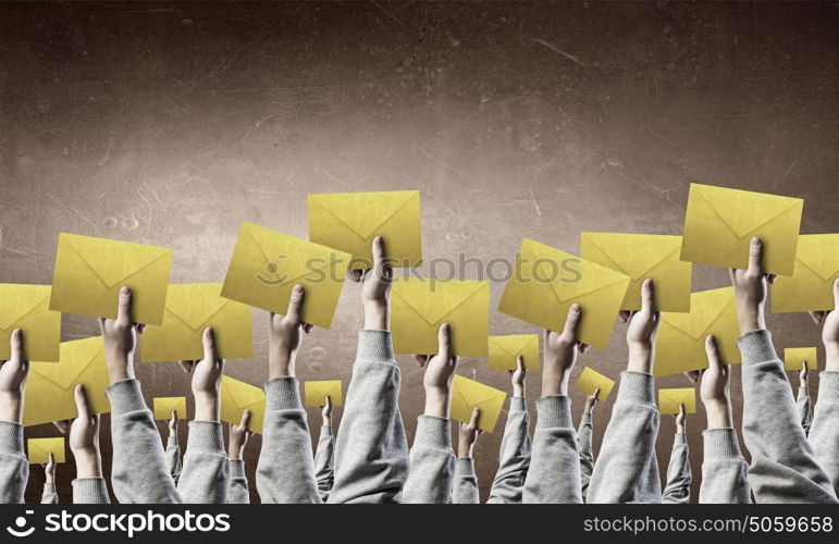 Teamwork and Email concept. Crowd of businesspeople lifting up hands with email signs