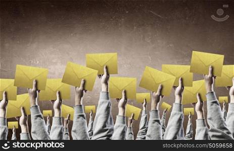 Teamwork and Email concept. Crowd of businesspeople lifting up hands with email signs