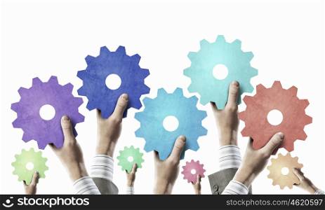 Teamwork creative work concept. Group of business people with raised hands holding cogwheels