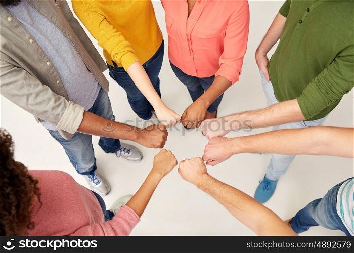 teamwork, friendship, international, gesture and people concept - group of hands making fist bump
