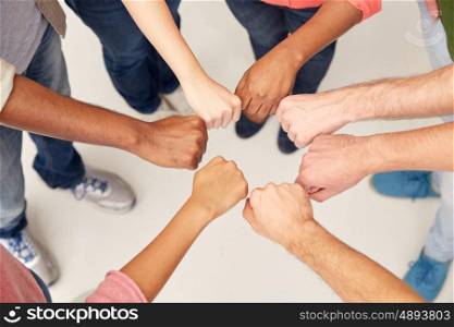 teamwork, friendship, international, gesture and people concept - group of hands making fist bump
