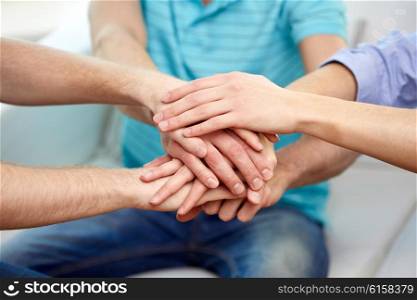 teamwork, friendship, unity, cooperation and gesture concept - close up of friends holding hands on top of each other
