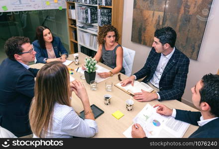 Teamwork having a meeting about business strategy sitting at table in company headquarters. Teamwork in a business meeting on headquarters