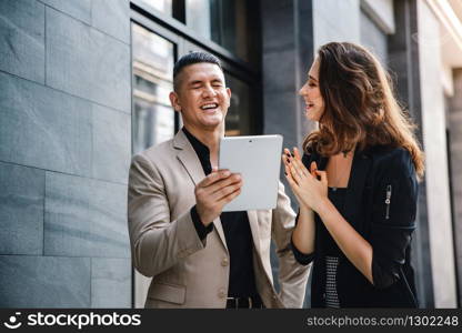 Teamwork or Work Together Concept. Businessman and Business Woman Working on Tablet outside the Office