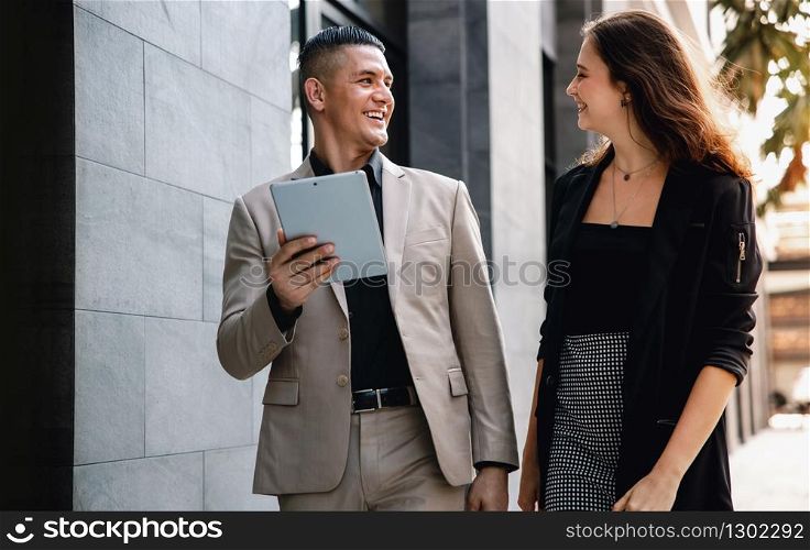 Teamwork or Work Together Concept. Businessman and Business Woman Working on Tablet outside the Office