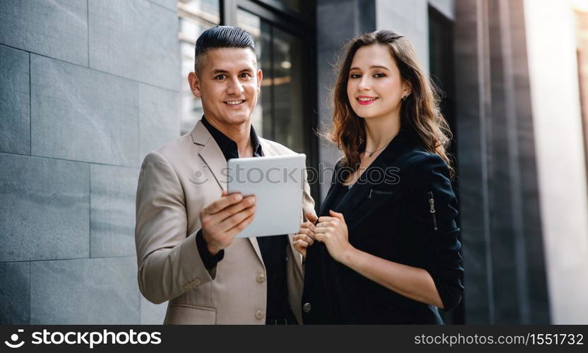 Teamwork or Work Together Concept. Portrait of Businessman and Business Woman Working on Tablet outside the Office