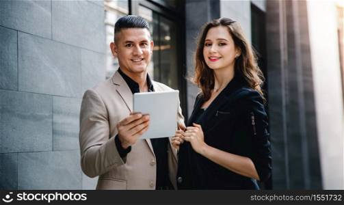 Teamwork or Work Together Concept. Portrait of Businessman and Business Woman Working on Tablet outside the Office
