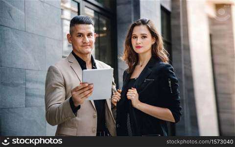 Teamwork or Work Together Concept. Portrait of Businessman and Business Woman Working on Tablet outside the Office