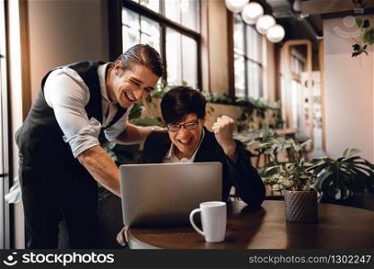 Teamwork or Working Together Concept. Two Businessman Working on Laptop in Creative Working Space. Work Partner Glad for Project Success