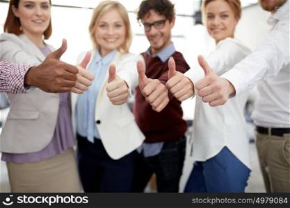 teamwork, people, gesture and technology concept - happy business team showing thumbs up at office. happy business team showing thumbs up at office