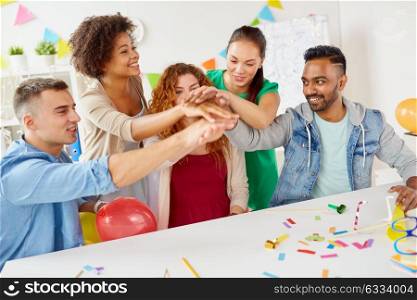 teamwork, success and celebration concept - happy business team holding hands together at office corporate party. happy business team at office party holding hands