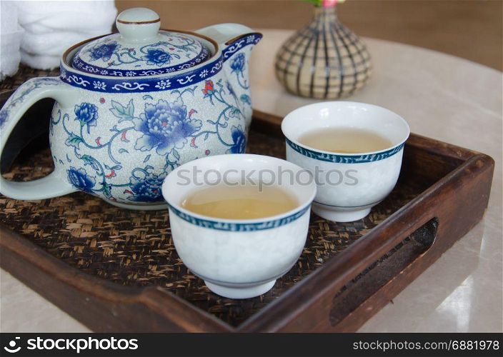 Teapot and cup of tea on table.