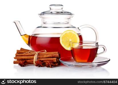 Teapot and tea in cup with spices and lemon isolated on white background
