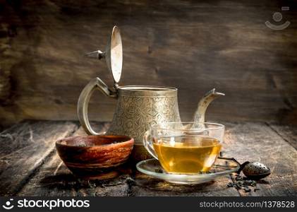 Teapot with fragrant Indian tea. On a wooden background.. Teapot with fragrant Indian tea.