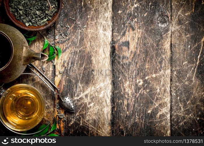 Teapot with fragrant Indian tea. On a wooden background.. Teapot with fragrant Indian tea.
