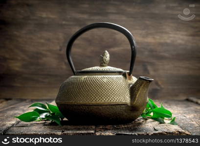 Teapot with fragrant Indian tea. On a wooden background.. Teapot with fragrant Indian tea.