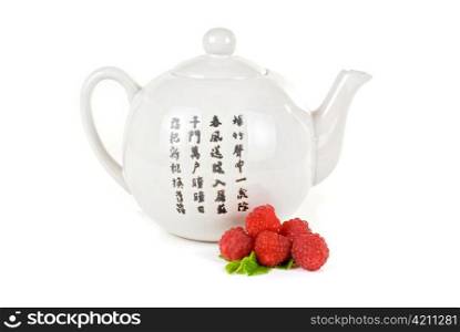 Teapot with fruit tea and berries on a white background