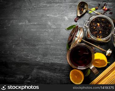 Teapot with tea and lemon. On a black wooden background.. Teapot with tea and lemon.