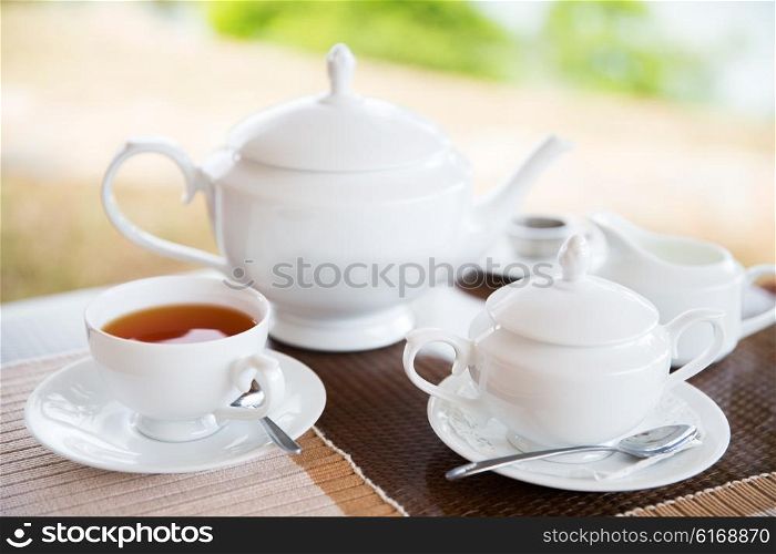 teatime, drink and object concept - close up of tea service on table at restaurant or teahouse