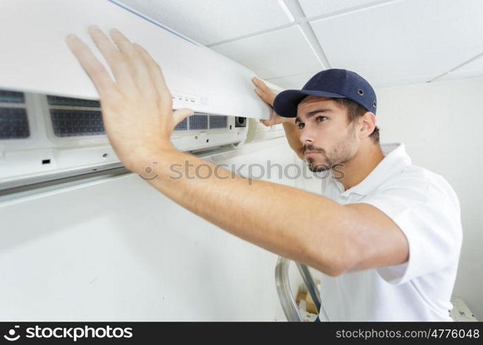 tech guy carefully installing new ac