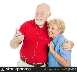Tech savvy senior couple listens to mp3s on their media player. Isolated on white.