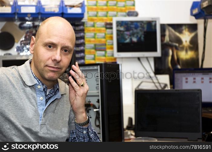 Tech support on the phone in a small computer repair shop