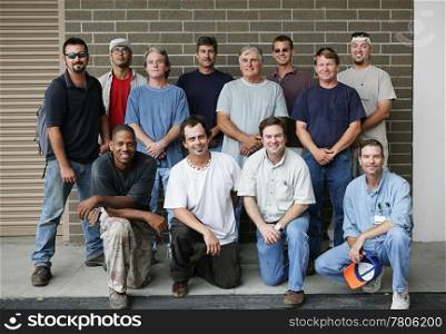 Technical college class photo of a group of handsome blue collar working men. Diverse ages and ethnicities represented.