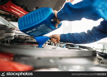 Technician change oil in the car engine. Vehicle motor maintenance, auto-service. Technician change oil in the car engine
