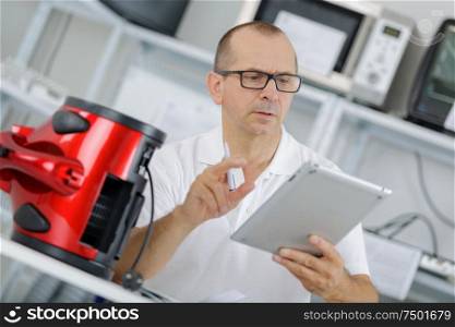 technician checks his table to fix a vaccum cleanner
