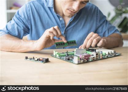 technician inserting ram socket computer motherboard