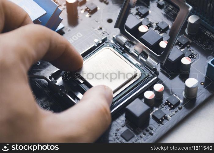 Technician install CPU processor chip in socket on computer motherboard