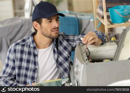 technician repairing a washing machine