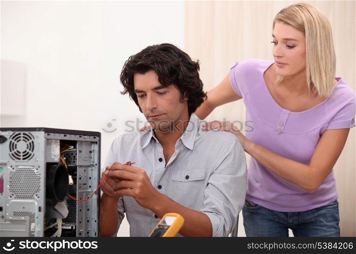Technician repairing PC for attractive colleague