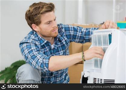 technician repairs an air conditioning unit