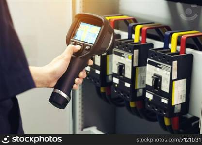Technician use thermal imaging camera to check temperature in factory