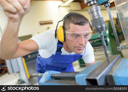 Technician using bench drill