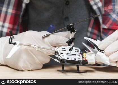 technician wearing gloves repairing helicopter toy