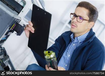 technician with clipboard checking how to fix printer