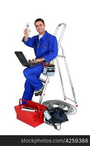 Technician with laptop and cellphone leaning on a ladder
