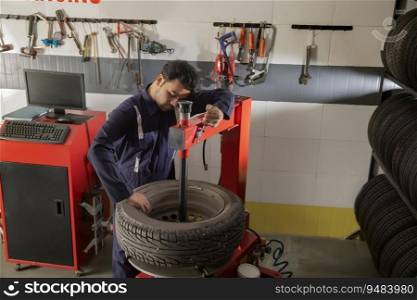 Technician working on a tyre changer a tyre shop
