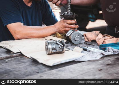 Technicians are helping to assemble the car power steering gearbox.